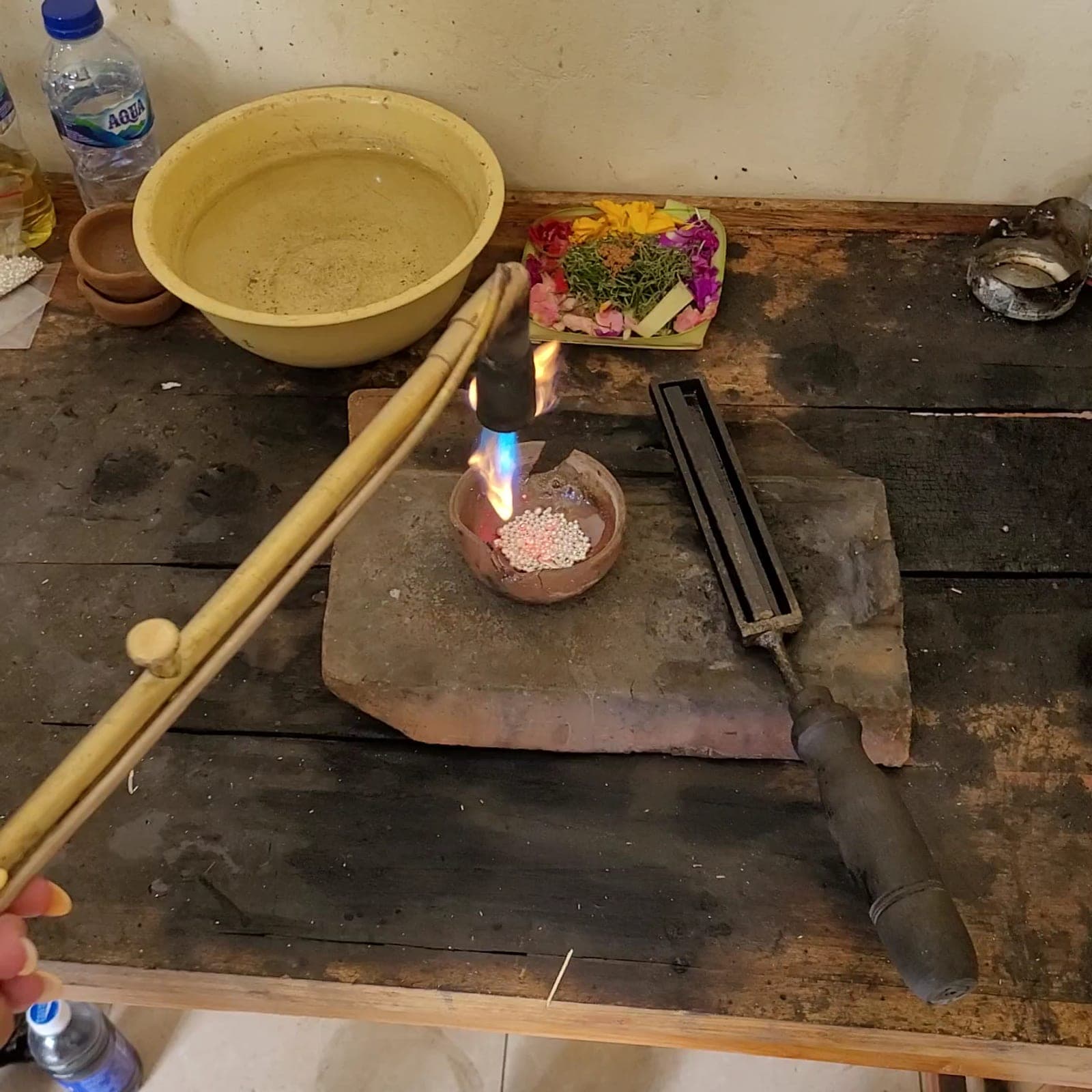Silver being melted with a torch on the workbench at Our Jewellery Silver Class in Kuta