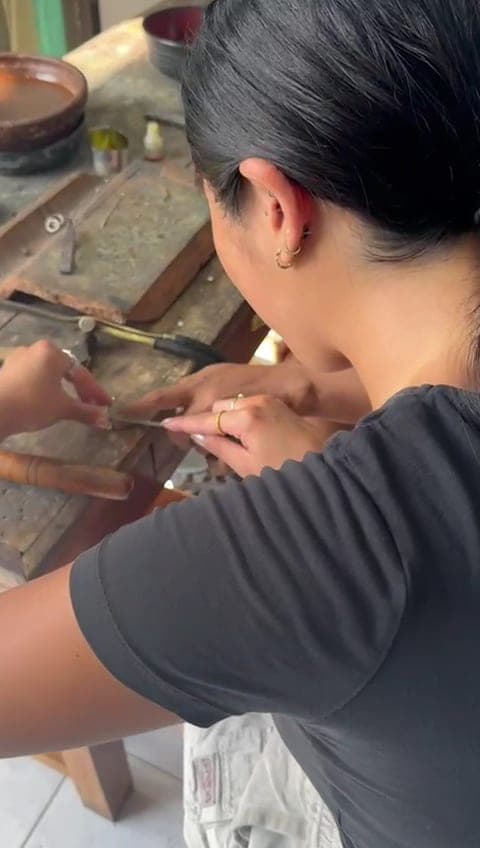 A guest filing her silver ring at the workbench during a single silver class in Kuta